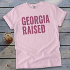 Light pink t-shirt with "GEORGIA RAISED" in maroon text.