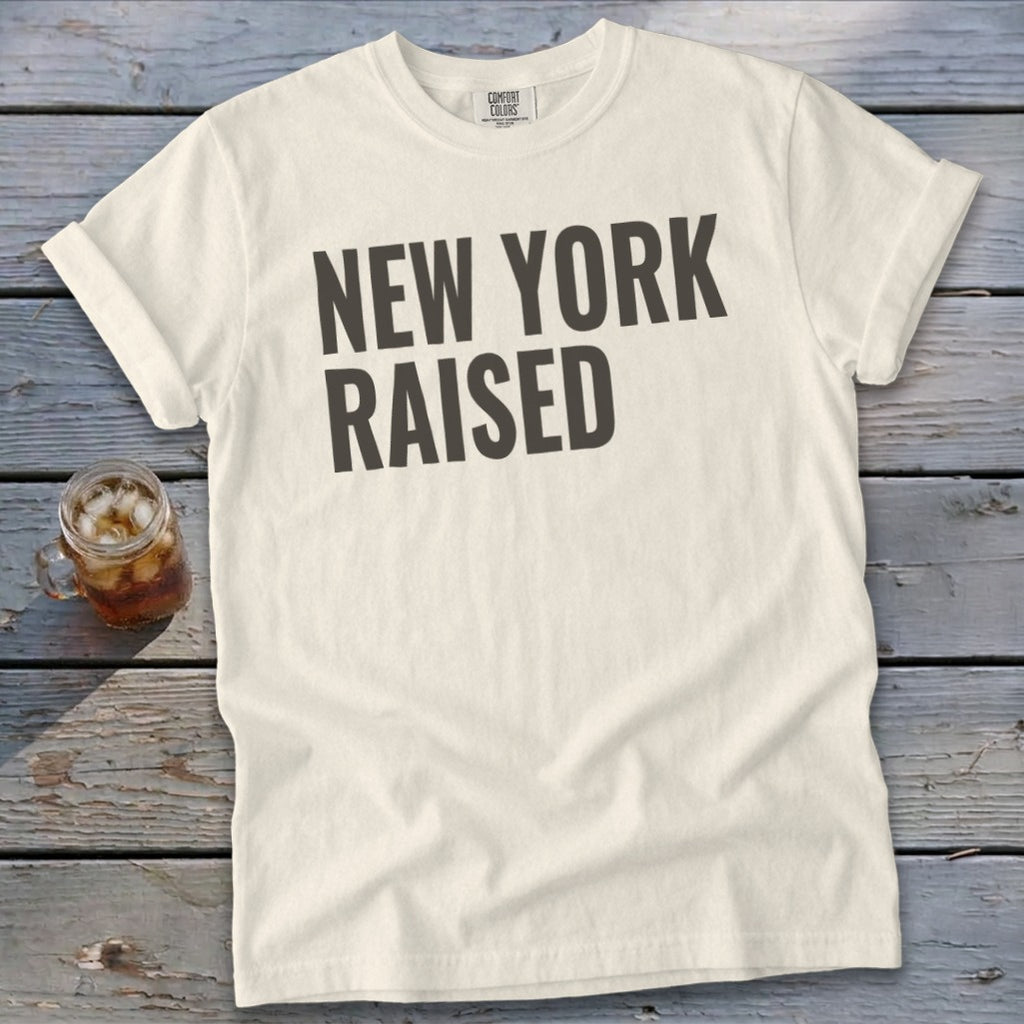 Cream t-shirt with "NEW YORK RAISED" text and a glass of iced tea.