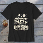 A black V-neck t-shirt featuring a graphic of three figures looking at mountain lights.