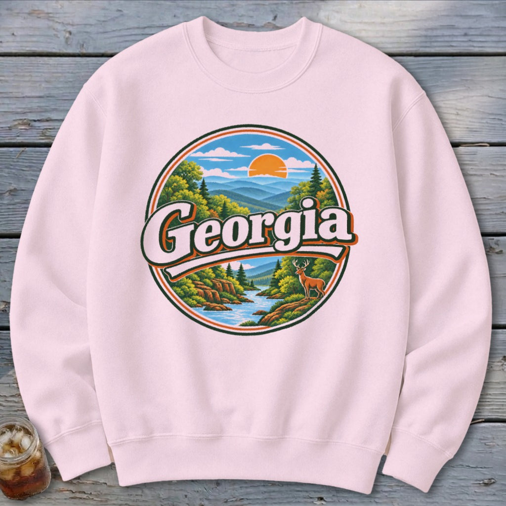Pink sweatshirt with a circular graphic of a Georgia landscape with a deer.