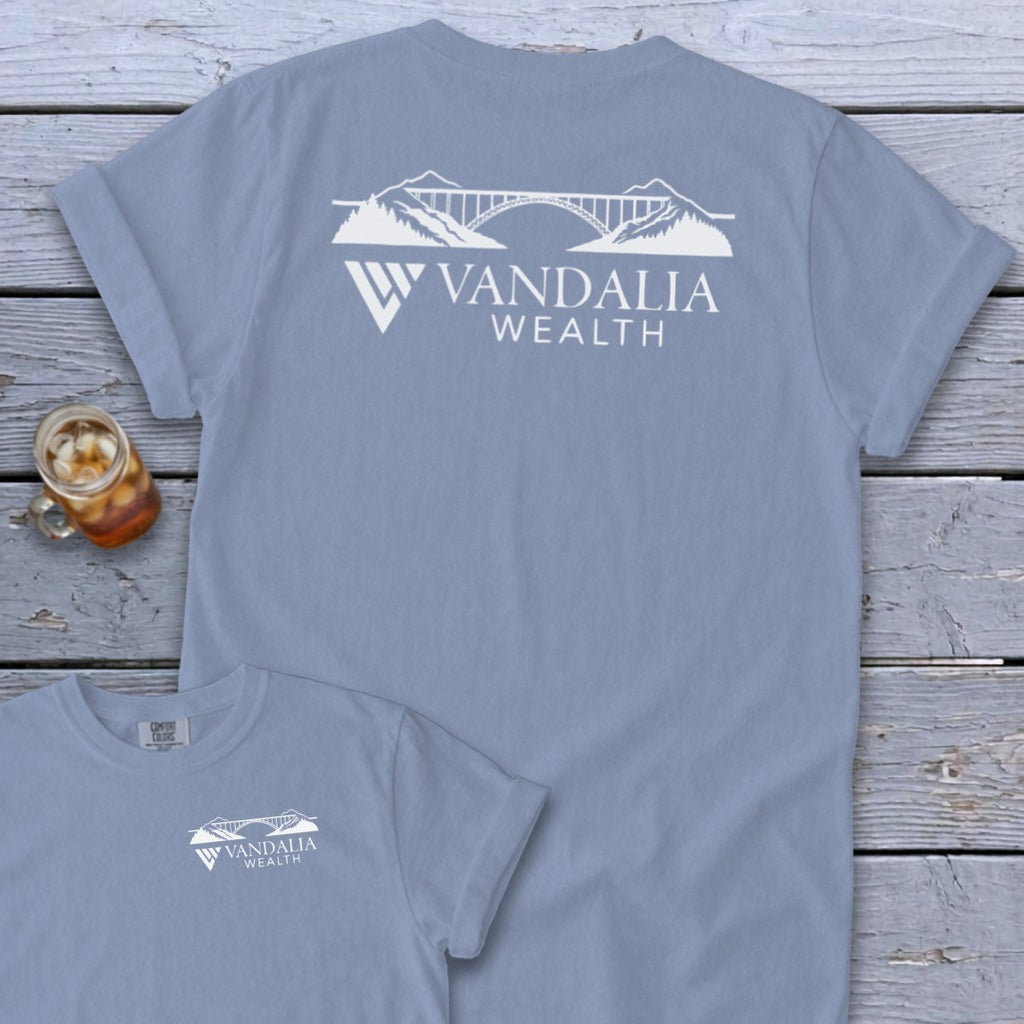 Light blue t-shirt with white Vandalia Wealth logo featuring a bridge and mountains.