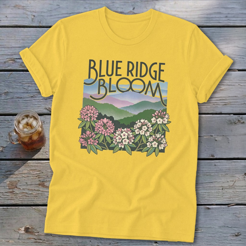 Yellow t-shirt with "Blue Ridge Bloom" text over a mountain landscape and flowers.