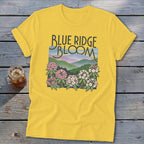 Yellow t-shirt with "Blue Ridge Bloom" text over a mountain landscape and flowers.