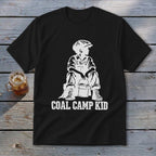 Black t-shirt with white graphic of a boy in overalls and cap sitting with a bucket, text "COAL CAMP KID".