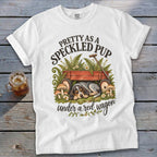 White t-shirt with graphic "Pretty as a Speckled Pup under a red wagon" and sleeping dog.