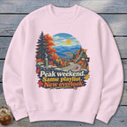 Sweatshirt with mountains, trees, road, and text: Peak weekend. Same playlist. New overlook.