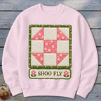 Pink sweatshirt with "Shoo Fly" text and a quilt block design.