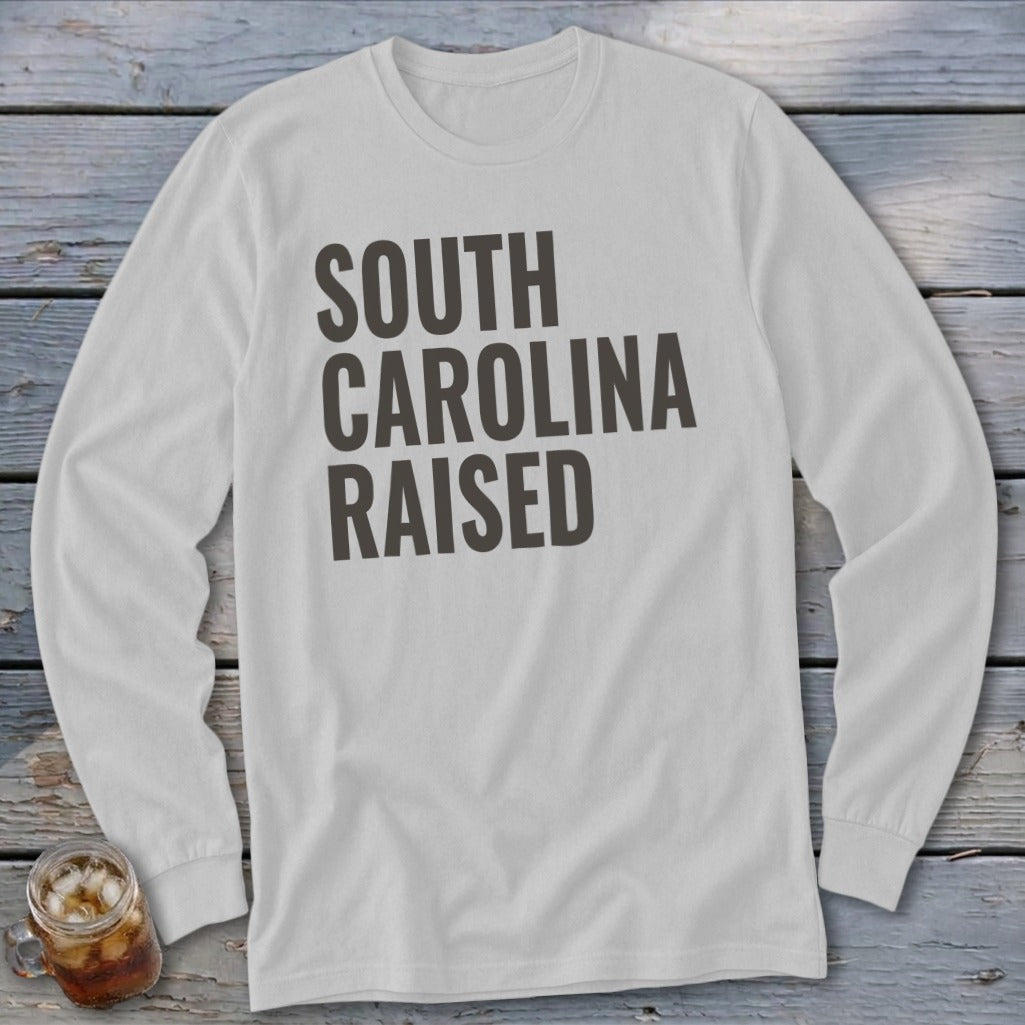 White long-sleeve shirt with "South Carolina Raised" text in dark gray.