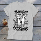 T-shirt graphic with text "BAREFOOT ON THE CRICK BANK" and bare feet on rocks.