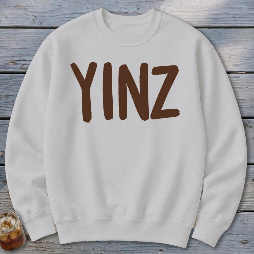 White sweatshirt with brown "YINZ" lettering centered on chest