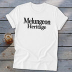 A white t-shirt with rolled sleeves features the black text "Melungeon Heritage" centered on the chest.