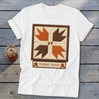 White t-shirt with a "Turkey Track" quilt block design and text.