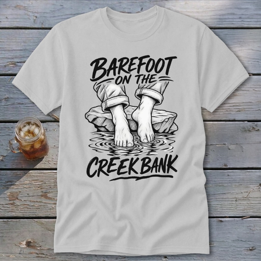 T-shirt graphic of bare feet in water with text "BAREFOOT ON THE CREEK BANK".
