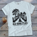 White t-shirt with black graphic of a farmhouse, trees, fence, and the words "Old Home Place".