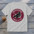 A light gray t-shirt featuring a circular maroon graphic of a bear lounging on a porch swing, accompanied by the text "Professional Porch Sitter".