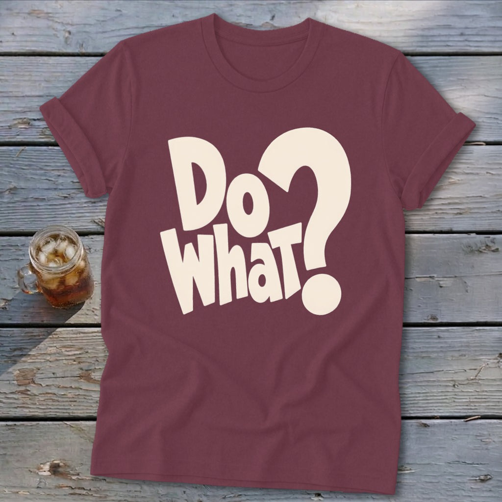 Maroon t-shirt with rolled sleeves featuring cream-colored text that reads Do What? resting on a rustic wooden background.