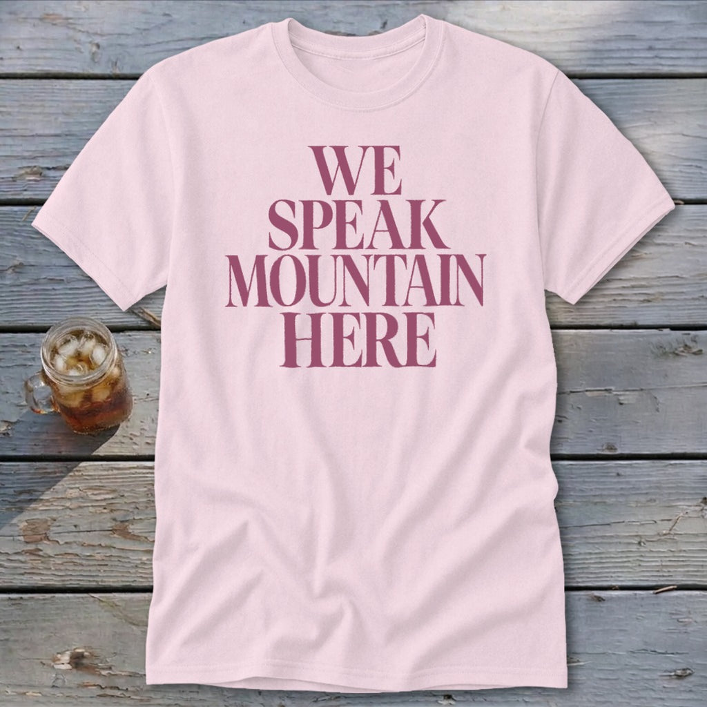 Pink t-shirt with maroon text that reads "WE SPEAK MOUNTAIN HERE".