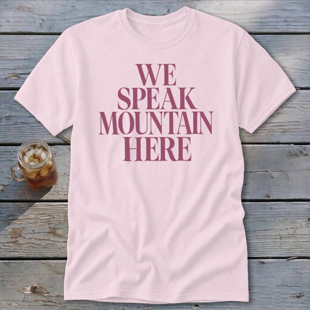 Pink t-shirt with maroon text that reads "WE SPEAK MOUNTAIN HERE".