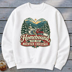 White sweatshirt with "Homebound For The Mountain Christmas" text and winter mountain scene.