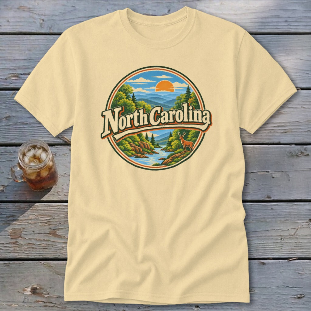 Light yellow t-shirt with circular "North Carolina" graphic featuring mountains, trees, and a deer.