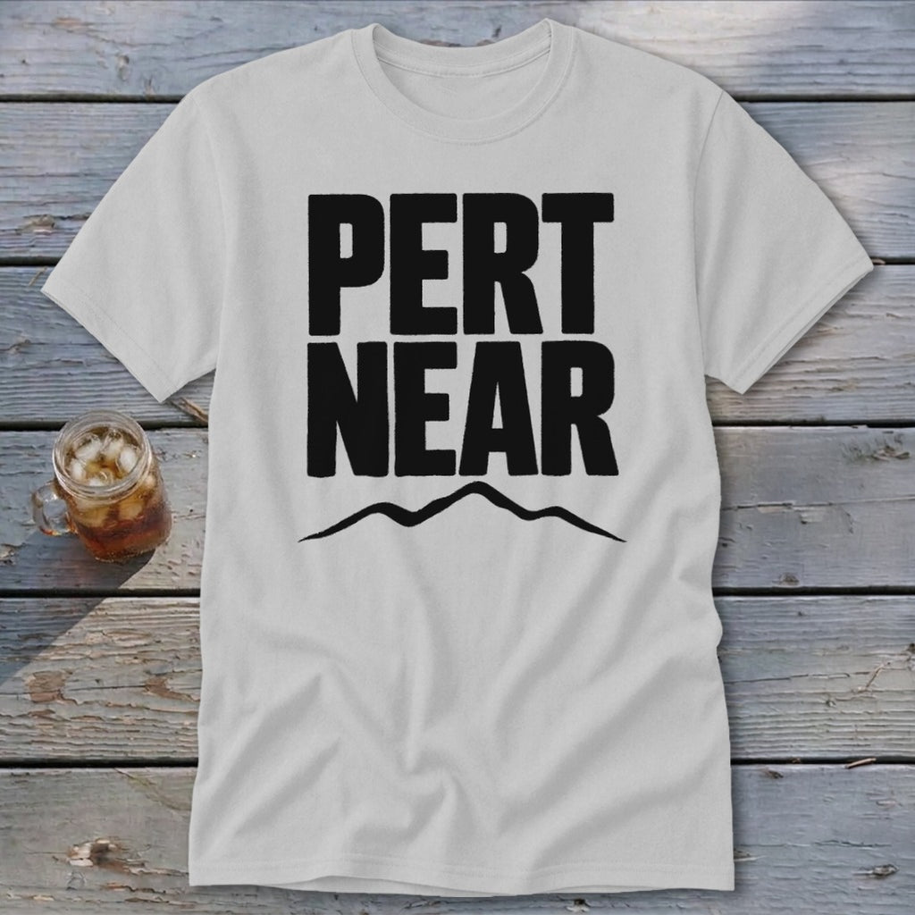 Light gray t-shirt with black Pert Near text and a mountain silhouette on a wooden surface.