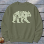 Olive green crewneck sweatshirt featuring a light green graphic of a walking bear filled with the text Appalachia.