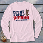Pink long-sleeve shirt with "PLUMB TUCKED OUT AND IT AIN'T EVEN DINNER" text and rocking chair graphic.