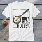 White t-shirt with a banjo graphic and the text "BORN IN THE HOLLER".