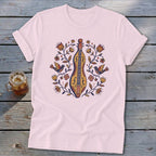 Pink t-shirt with folk art print of a dulcimer surrounded by birds and flowers.