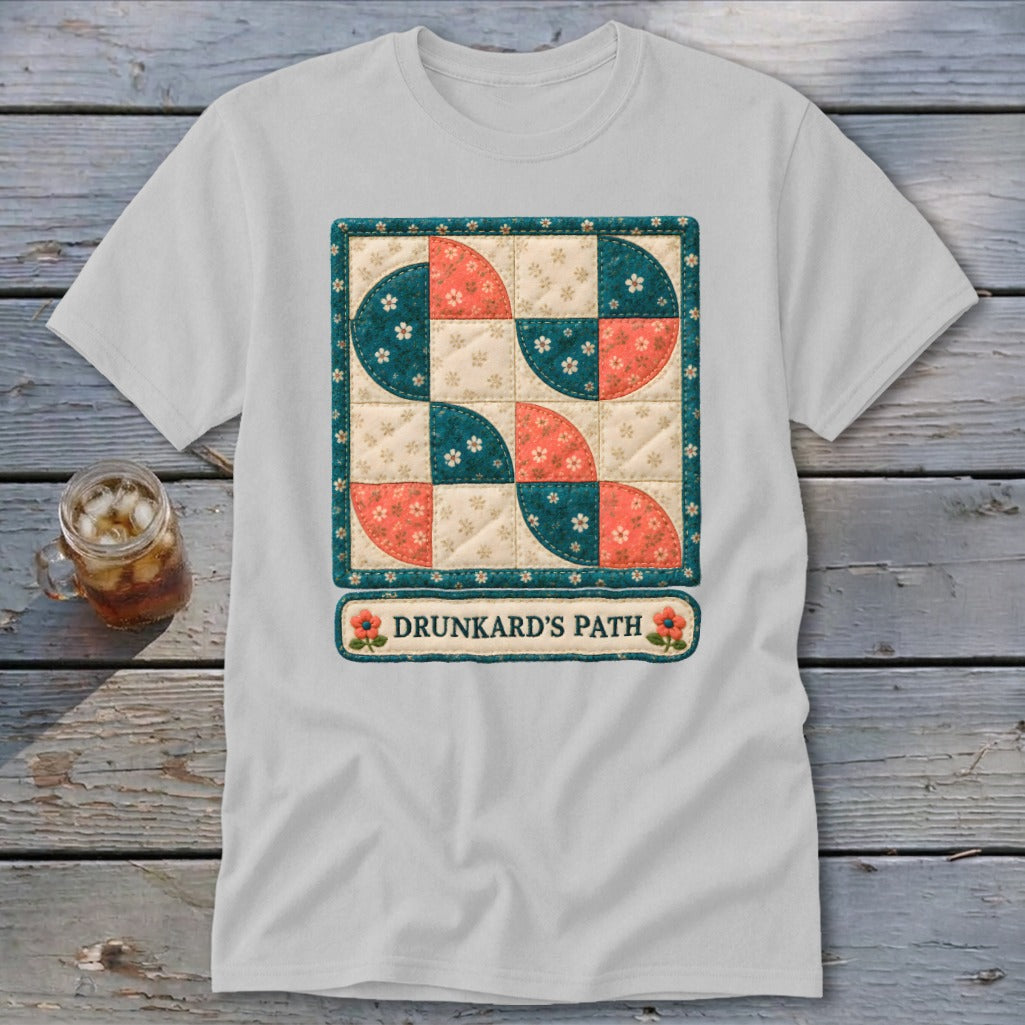 White t-shirt with "Drunkard's Path" quilt design featuring coral, teal, and cream squares.