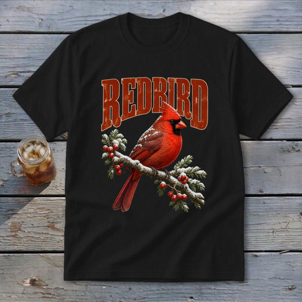 A black t-shirt features a graphic of a red cardinal on a snowy branch with red berries and the text REDBIRD.