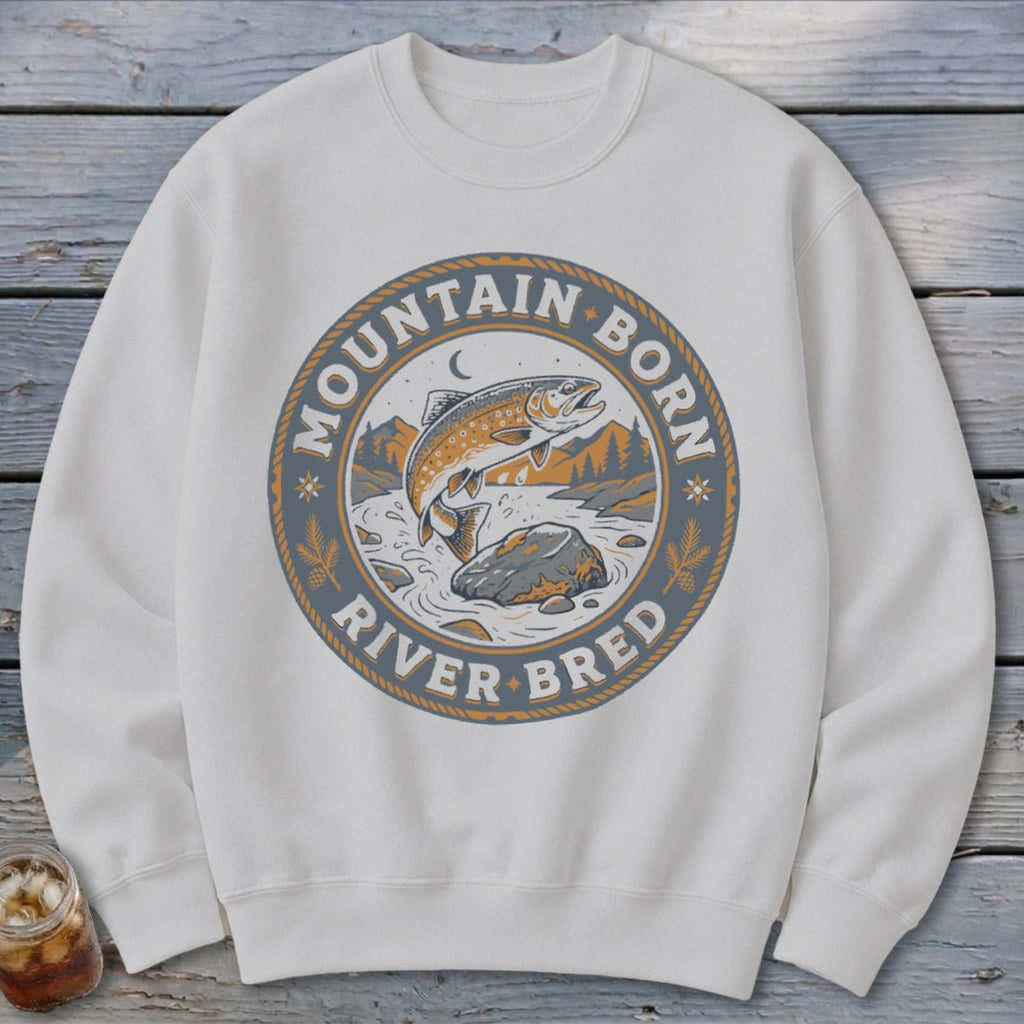 White sweatshirt with a circular graphic of a jumping trout, text "MOUNTAIN BORN RIVER BRED".