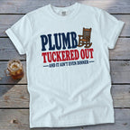 White t-shirt with "PLUMB TUCKERED OUT AND IT AIN'T EVEN DINNER" text and rocking chair graphic.