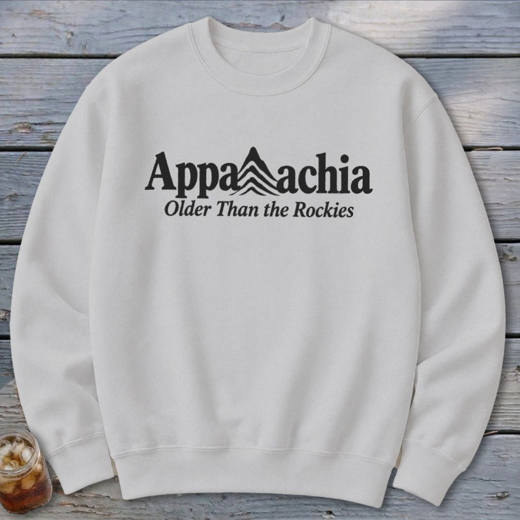 White crewneck sweatshirt with "Appalachia Older Than the Rockies" text and mountain graphic.