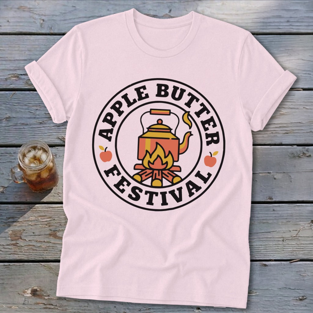 Pink t-shirt with Apple Butter Festival circular logo featuring a kettle over a fire.