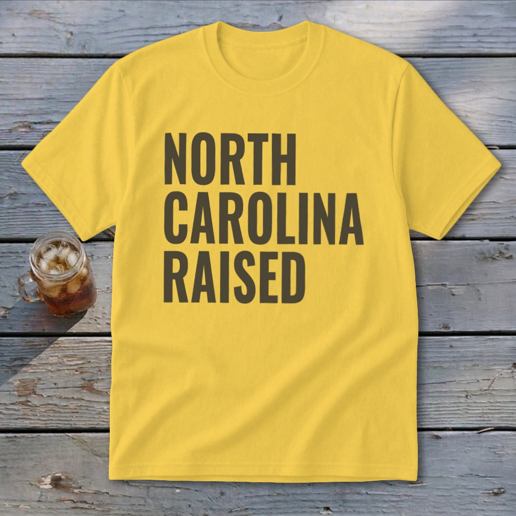 Yellow t-shirt with "NORTH CAROLINA RAISED" in dark text.