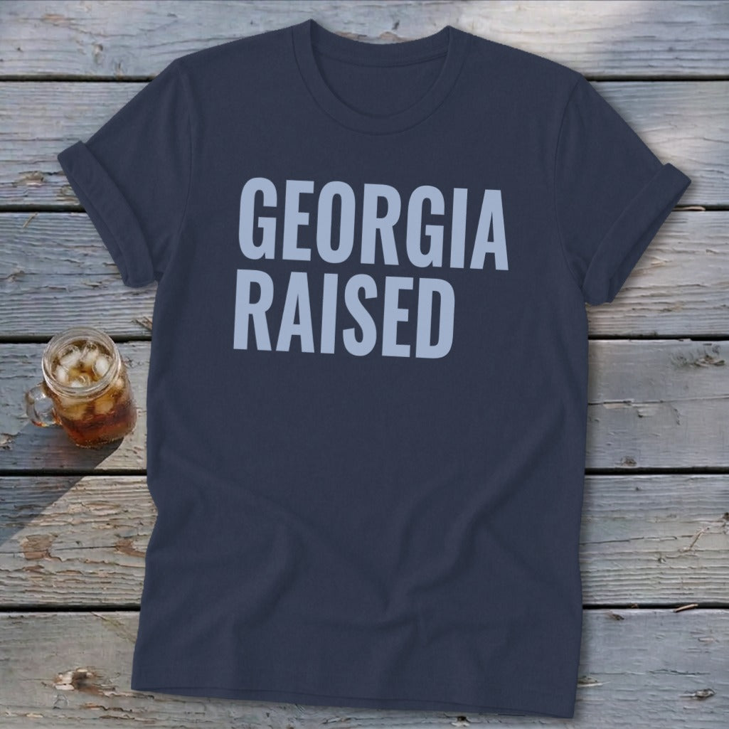 Navy t-shirt with "GEORGIA RAISED" in light blue text.