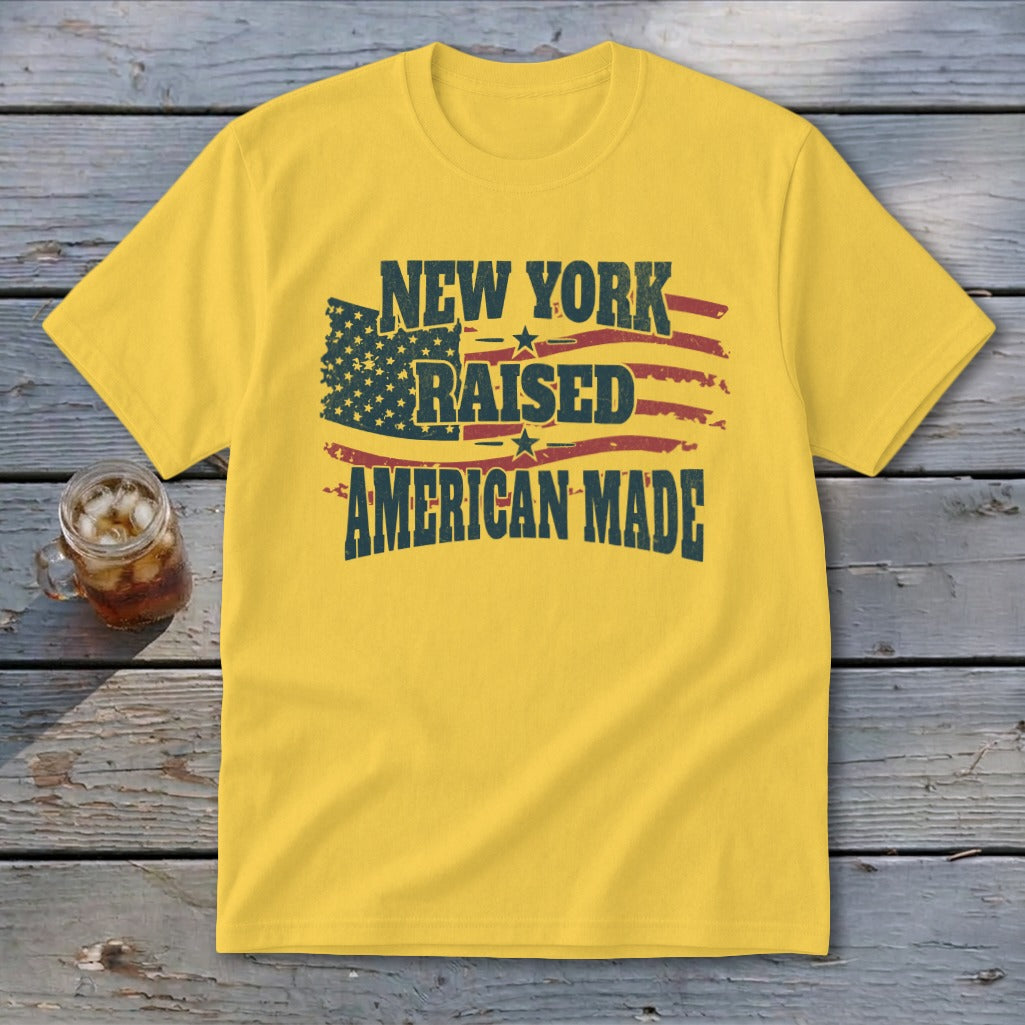 A yellow t-shirt featuring the text New York Raised American Made and an American flag design.