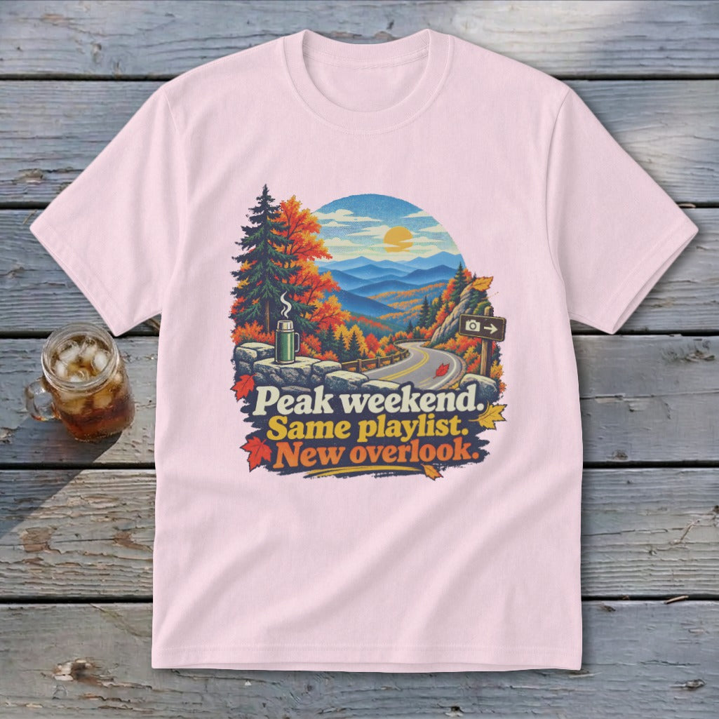 Pink t-shirt with autumn mountain scene and text: Peak weekend. Same playlist. New overlook.