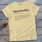 A pale yellow t-shirt with black text defining Appalachia displayed on a wooden surface.