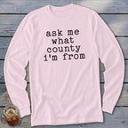 Light pink long sleeve shirt with black text asking "ask me what county I'm from."