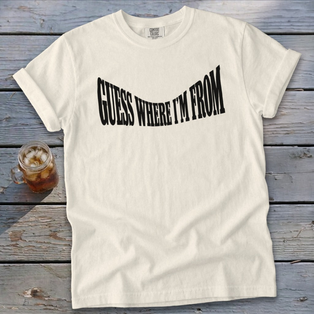Cream t-shirt with "GUESS WHERE I'M FROM" text in black, wavy font.