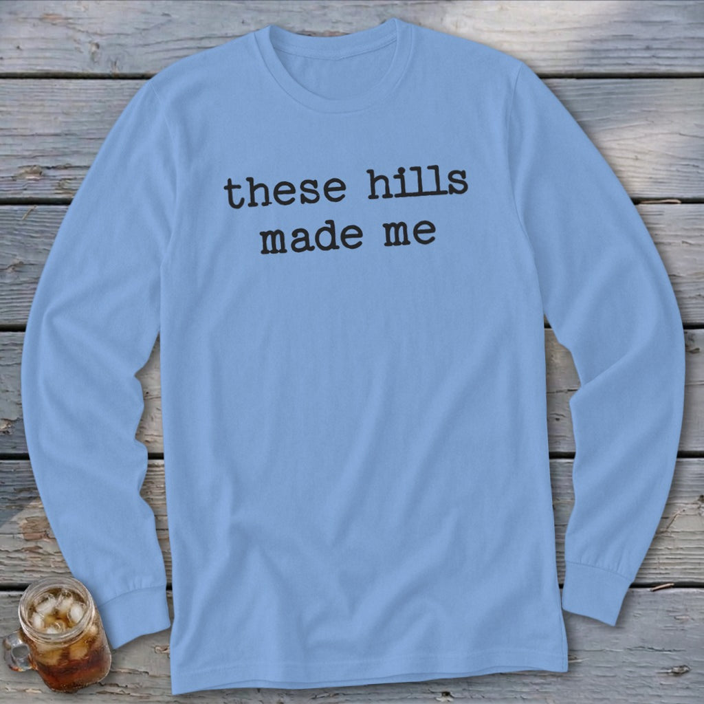 Light blue long-sleeve shirt with black text "these hills made me."