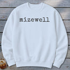 White sweatshirt with black typewriter text "mizewell" across the chest.