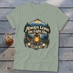 T-shirt with a graphic of a lantern, mountains, and text "Always Leave the Light On Come On In".
