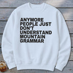 White sweatshirt with black text that reads "Anymore people just don't understand mountain grammar."