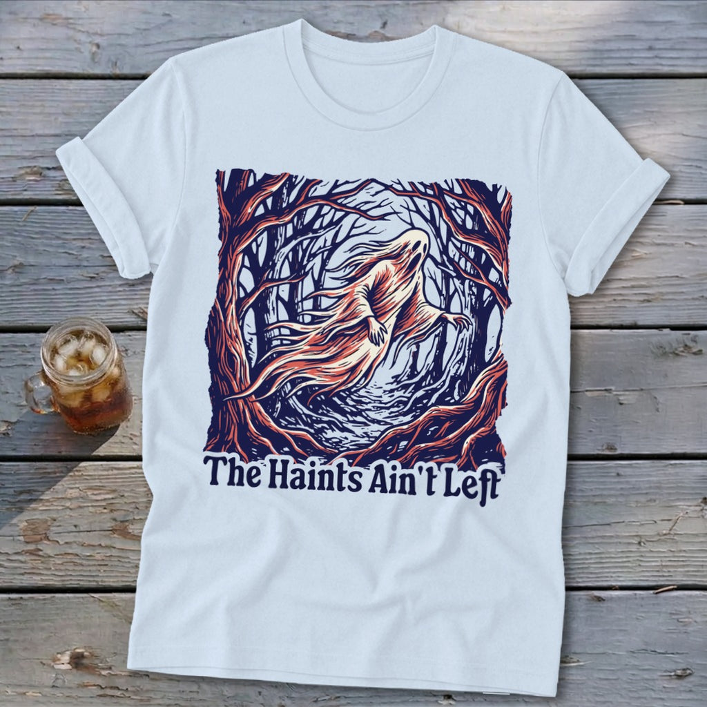 White t-shirt with a ghost in a forest and the text "The Haints Ain't Left".