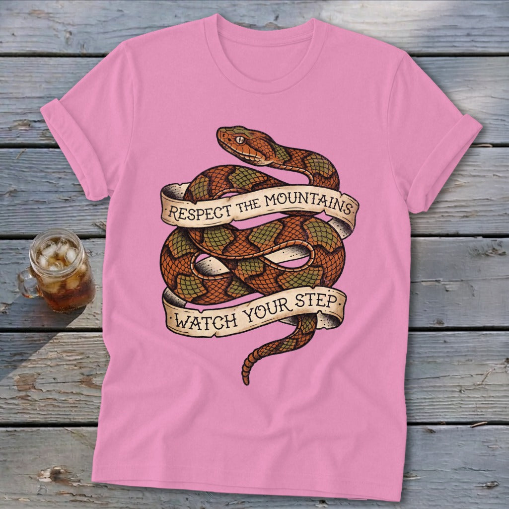 Pink t-shirt with coiled snake graphic and text "Respect the Mountains, Watch Your Step."