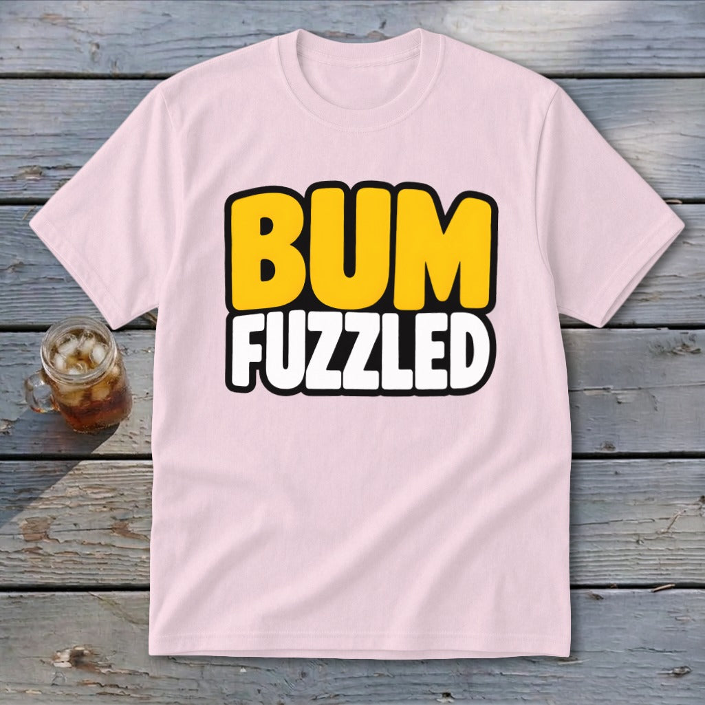 Light pink crewneck t-shirt featuring the text BUM FUZZLED in yellow and white on a weathered wooden surface.