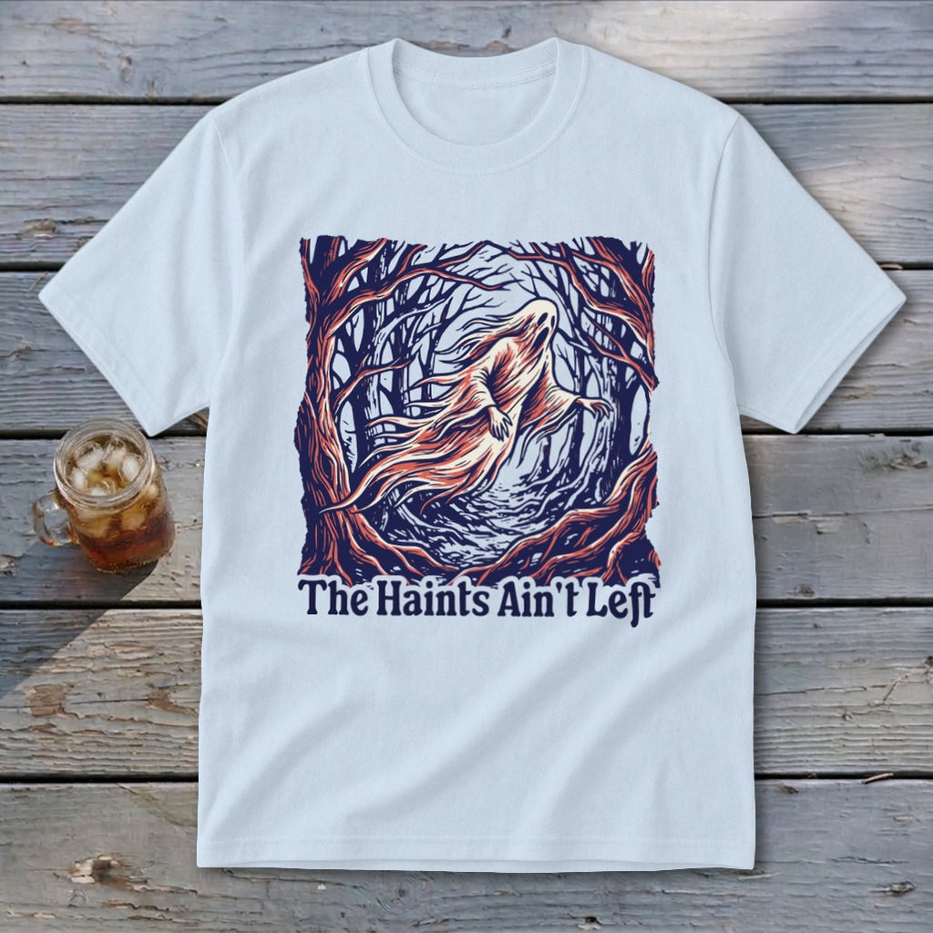 White t-shirt with a graphic of a ghost in a dark forest and text "The Haints Ain't Left".